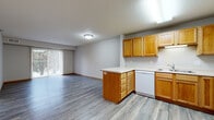 Located at 1321 Lake Dr W in Chanhassen, MN, this two-bedroom, one-bathroom residence offers a practical and comfortable single-floor layout. The open-concept kitchen flows seamlessly into the living area, creating a connected and functional space. The kitchen is well-equipped with warm oak cabinetry, white appliances including a refrigerator, electric range, microwave, and dishwasher, along with a peninsula counter that provides additional prep and casual dining space. Light wood-style flooring runs throughout the main living areas, adding a clean, cohesive look.

The living room receives natural light through a large sliding glass door fitted with vertical blinds, which opens to an outdoor view and patio area. Both bedrooms are carpeted in a neutral gray tone, providing a comfortable and quiet retreat. The spacious primary bedroom offers ample room for furnishings, while the second bedroom features a window that brings in natural light. The full bathroom is finished with light ceramic tile flooring and includes a tub-shower combination. Textured ceilings and warm wood-toned trim and doors carry consistent character throughout the home. This well-organized residence is ideally situated in the welcoming community of Chanhassen, Minnesota.