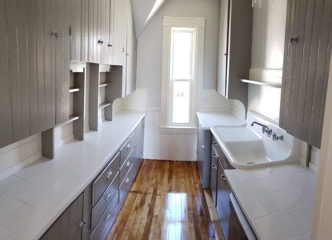 Galley Kitchen has many cabinets, newly installed dishwasher, antique cast iron sink and tin ceilings - 32 Hevey St