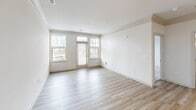 This 770 square foot apartment offers a thoughtful blend of comfort and style in a compact space. The single-floor layout maximizes efficiency, featuring one bedroom, one bathroom, and an open-concept kitchen and living area. The primary bedroom, at 240 square feet, provides ample space for rest and relaxation.

The kitchen showcases modern aesthetics with white cabinetry, stainless steel appliances, and a sleek granite countertop. Pendant lighting adds a touch of elegance, while the mosaic tile backsplash introduces visual interest. The open design seamlessly connects to the living area, perfect for entertaining or everyday living.

Throughout the apartment, light wood-look flooring creates a bright, airy atmosphere, complemented by crisp white walls and trim. Large windows in the living area and bedroom invite natural light and offer views of the surrounding neighborhood. Plush carpeting in the bedroom adds warmth and comfort underfoot.

The bathroom features a clean, contemporary design with a white vanity, granite countertop, and a combination tub-shower with a curved rod for added space. Wood-look flooring continues here, maintaining design consistency.

Additional amenities include a ceiling fan in the living area for improved air circulation and window blinds for privacy and light control. The apartment's neutral color palette provides a versatile backdrop for personal decorating styles, making it an ideal canvas for creating a personalized urban retreat.