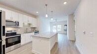 This single-floor, 3-bedroom, 2-bathroom home features a clean, modern design with a bright and airy open-concept layout. The combined kitchen and dining area serves as the heart of the home, showcasing white shaker cabinetry, a classic tile backsplash, stainless steel appliances, and a granite-topped center island illuminated by stylish pendant lighting. Light wood-look flooring runs throughout the main living areas, enhancing the sense of openness and continuity. The living room extends naturally from the kitchen, featuring a ceiling fan and a glass door that allows ample natural light and provides outdoor access. Three well-sized bedrooms are finished with plush carpet flooring and ceiling fans, each offering a comfortable and private retreat. The primary bedroom provides generous space and includes dedicated closet storage. Four closets are distributed throughout the home, ensuring abundant storage. The two bathrooms are finished with granite countertops, white cabinetry with brushed hardware, and light tile flooring. A dedicated laundry room accommodates a full-sized washer and dryer and includes built-in shelving. Connecting hallways and a thoughtful floor plan contribute to an efficient and functional flow throughout the home.