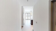Located at 4650 N Central Ave in Phoenix, Arizona, this single-floor residence presents a clean, contemporary design with a bright and open layout. The entryway leads through a hallway into the main living area, where light-toned tile flooring, white walls, and a ceiling fan create a comfortable and airy atmosphere. Large French doors at the far end of the living space flood the interior with natural light and provide access to the outdoors, enhancing the sense of openness throughout.

The kitchen is a standout feature, showcasing a granite-topped island with an undermount sink and a sleek pull-down faucet. Stylish pendant lighting hangs above the island, complementing the track lighting overhead. Dark cabinetry provides rich contrast against the white walls, and stainless steel appliances — including a refrigerator, range, and built-in microwave — complete the modern culinary space.

The bedroom offers carpeted flooring, a ceiling fan, and a sliding-door closet with built-in shelving, providing practical storage in a comfortable setting. An additional room with tile flooring and a glazed exterior door offers flexibility as a den or office, with ample natural light from an adjacent window. The bathroom features a dark-toned vanity with an integrated sink, tile flooring, and a walk-in shower area, maintaining the unit's consistent modern aesthetic throughout.