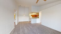 Located at 4017 Crosswind Court in Melbourne, FL, this single-story 2-bedroom, 2-bathroom home offers a thoughtfully designed layout with a welcoming open-concept feel. The combined living room and kitchen area is anchored by soaring vaulted ceilings and a ceiling fan, creating an airy and spacious atmosphere. The kitchen features warm wood cabinetry, a peninsula breakfast bar, hardwood-style flooring, and white appliances including a refrigerator, range, and built-in microwave. Carpet flows throughout the living area and bedrooms, adding comfort underfoot. The primary bedroom is generously sized, boasting vaulted ceilings, a ceiling fan, a sliding glass door leading to a private balcony with serene water views, and a walk-in closet with wire shelving. The second bedroom also enjoys a ceiling fan and a large window framing picturesque water and neighborhood views. Both bathrooms include vanities with countertop sinks and hardwood-style flooring. Additional features include two hallways, a utility room, and two closets for ample storage. Connecting hallways are bright and clean, with soft carpet and neutral tones throughout. The overall aesthetic is clean, light-filled, and move-in ready.