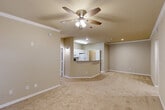 Located at 10720 Linkwood Ct in Baton Rouge, Louisiana, this two-story, two-bedroom, two-bathroom home offers a well-organized layout across two floors. The main living level hosts an open-concept living room, dining area, and kitchen, all finished with warm neutral tones and plush carpeting. The kitchen is equipped with white cabinetry, a double-basin sink, stone-look countertops, a curved breakfast bar peninsula, and wood-look flooring — seamlessly connecting to the living and dining areas, which feature ceiling fans with light fixtures and crown molding. A dedicated in-unit laundry room with side-by-side washer and dryer hookups and built-in shelving adds everyday convenience. The primary bedroom is generously sized, featuring carpet flooring, a ceiling fan, crown molding, and access to a closet. The second bedroom is well-proportioned with natural light from a window and its own ceiling fan. Both bathrooms are cleanly appointed, with the primary bath offering a wide vanity, a large mirror with Hollywood-style lighting, and a tub-shower combination. Multiple closets throughout the home provide ample storage. A private patio completes the space, offering an outdoor retreat.