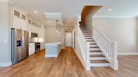 This two-story residence offers a generous 1640 square feet of living space, thoughtfully distributed across two floors. The ground floor, spanning 1020 square feet, houses the main living areas, including an open-concept kitchen and living room. The upper level, at 620 square feet, likely accommodates the bedrooms and additional bathrooms.

The home boasts 3 bedrooms, with the primary bedroom offering a spacious 190 square feet. An impressive 5 bathrooms ensure convenience for residents and guests alike. Additional rooms include a laundry area and a dedicated closet space, enhancing the home's functionality.

The interior is characterized by its bright and airy atmosphere, achieved through large windows that flood the space with natural light. Hardwood floors throughout add warmth and elegance to the home. The walls are painted in a neutral tone, creating a versatile backdrop for various decor styles.

A staircase with white railings leads to the upper floor, seamlessly connecting the two levels. The open layout of the main living area promotes a sense of spaciousness and facilitates easy movement between spaces. Crown molding and baseboards add refined architectural details, elevating the overall aesthetic of this well-appointed home.