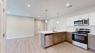 Located at 1154 N Old Castle Rd in Nixa, MO, this single-story home offers a thoughtfully designed layout across three bedrooms and two bathrooms. The open-concept kitchen and living area serves as the heart of the home, showcasing light wood-look flooring, recessed lighting, and pendant lights above a spacious peninsula with a built-in sink. The kitchen features stainless steel appliances, a classic subway tile backsplash, white upper cabinetry, and warm-toned lower cabinets, creating a stylish two-tone aesthetic. The living room is bright and welcoming, with French doors that invite natural light and provide outdoor views, complemented by a ceiling fan and recessed lighting. Each bedroom is finished with plush carpet, neutral-toned walls, and windows that bring in ample daylight. The primary bedroom includes a ceiling fan for added comfort. Both bathrooms are finished consistently with light wood-look tile flooring, white shaker-style vanities with quartz countertops, backlit mirrors, and brushed gold hardware accents, lending a clean and modern feel. A dedicated laundry room adds everyday convenience. The overall ambiance is modern, clean, and move-in ready, with cohesive finishes carried throughout the entire home.
