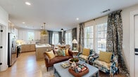 Located at 19020 Potts Park Ln in Davidson, NC, this thoughtfully designed 2-bedroom, 2-bathroom residence offers a comfortable and stylish single-floor layout. The heart of the home is a bright, open-concept living, dining, and kitchen area flooded with natural light from large windows dressed in patterned drapes. Light hardwood-style flooring flows seamlessly throughout, complementing the warm, neutral palette. The kitchen is a standout, featuring a two-tone design with white shaker upper cabinets paired with natural wood lower cabinets, quartz countertops, a classic subway tile backsplash, stainless steel appliances, and a central island with pendant lighting. The living area connects gracefully to the rest of the home through an elegant arched doorway. The primary bedroom offers a serene retreat, highlighted by a bold botanical accent wall, while its en-suite bathroom includes a double-sink vanity with quartz counters and a tiled walk-in shower. A spacious walk-in closet with built-in shelving and dual hanging rods adds generous storage. The second bedroom is equally comfortable, with direct access to a well-appointed full bathroom. A dedicated laundry room, multiple closets, and a welcoming entrance complete this functional and inviting home.