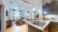 Located at 2525 S Voss Rd in Houston, TX, this one-bedroom, one-bathroom unit offers a thoughtfully designed layout across a single floor. The open-concept kitchen and living area serves as the heart of the home, featuring rich dark-wood cabinetry extending to the ceiling, stainless steel appliances, granite-style countertops, a peninsula with bar seating, and elegant pendant lighting. Light hardwood-style flooring flows throughout, complemented by a ceiling fan and large windows that invite an abundance of natural light into the living space. The bedroom is a comfortable retreat finished with plush carpet, large windows with outdoor views, and direct access to a well-organized walk-in closet. A second closet provides additional storage convenience. The bathroom features a full tub-shower combo, tile flooring, a dark-wood vanity with granite countertops, and clean white walls. A private balcony extends the living space outdoors, while an in-unit laundry area adds everyday convenience. A hallway connects the spaces with a clean, efficient flow. This unit combines modern finishes with a practical layout, making it a well-appointed home in the heart of Houston.
