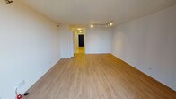 Situated in the heart of Chicago's prestigious Gold Coast neighborhood at 1122 N Dearborn Street, this single-floor residence offers a clean, modern aesthetic throughout. The main living area is an open, airy space finished with light-toned hardwood flooring and crisp white walls. Track lighting runs along the ceiling, providing flexible illumination across the generous layout. Floor-to-ceiling windows along one wall flood the space with natural light while framing views of the surrounding Chicago cityscape, creating a bright and inviting atmosphere.

The galley-style kitchen is efficiently designed with white upper cabinetry and dark lower cabinets topped with gray countertops. It is equipped with black appliances, including a refrigerator, electric range, microwave, and a stainless steel sink, all set over classic light ceramic tile flooring. The layout maximizes functionality within a compact footprint.

The bathroom features a timeless black-and-white mosaic tile floor, white subway tile surrounding the full soaking tub and shower combination, and a dark-stained vanity with a white countertop. A medicine cabinet and grab bar complete this well-appointed space. The unit's consistent use of neutral tones, modern finishes, and abundant natural light makes it a versatile and attractive space in one of Chicago's most sought-after locations.