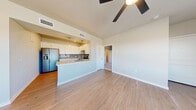 This single-story, 3-bedroom, 2-bathroom home offers a thoughtfully designed open-concept layout that maximizes both functionality and comfort. The living room is generously sized, featuring light wood-style flooring, ceiling fans, and an abundance of natural light streaming through multiple large windows that frame outdoor views. The space flows seamlessly into the kitchen, which is equipped with white shaker-style cabinetry, light quartz countertops, a blue-gray subway tile backsplash, stainless steel appliances including a French door refrigerator and electric range, and a peninsula that doubles as a breakfast bar with pendant lighting above.

The primary bedroom offers comfortable proportions, plush carpeting, a ceiling fan, corner windows for ample natural light, and access to a walk-in closet outfitted with wire shelving systems. The two bathrooms are clean and modern, with one featuring a subway-tiled tub/shower combo and brushed nickel fixtures. A dedicated laundry room houses a full-size washer and dryer with overhead wire shelving. Two closets provide additional storage throughout the home. Neutral tones, consistent finishes, and a practical floor plan make this a well-rounded and move-in-ready residence.