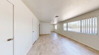Located at 301 N Decatur Blvd in Las Vegas, NV, this single-floor 3-bedroom, 1-bathroom residence offers a practical and well-organized layout. Light-toned tile flooring runs consistently throughout the home, creating a cohesive and easy-to-maintain interior. The open living area features a ceiling fan and large windows dressed with vertical blinds, allowing natural light to fill the space. The kitchen is equipped with distinctive blue-gray cabinetry and granite-style countertops, adding a touch of character to the home. The spacious primary bedroom occupies a generous portion of the floor plan, offering ample room for furnishings. Each bedroom includes a window for natural light, with at least one bedroom featuring a sliding-door closet with built-in shelving and hanging space. Three closets are distributed throughout the home, providing practical storage. The hallway connects the bedrooms to the shared full bathroom, which includes a soaking tub with shower, a gray vanity with granite countertop, and a small window for ventilation. Wall sconces in the hallway and secondary bedrooms add a warm lighting accent. The clean, neutral palette throughout creates a bright and inviting atmosphere.