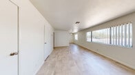 Located at 301 N Decatur Blvd in Las Vegas, NV, this single-floor 3-bedroom, 1-bathroom residence offers a practical and well-organized layout. Light-toned tile flooring runs consistently throughout the home, creating a cohesive and easy-to-maintain interior. The open living area features a ceiling fan and large windows dressed with vertical blinds, allowing natural light to fill the space. The kitchen is equipped with distinctive blue-gray cabinetry and granite-style countertops, adding a touch of character to the home. The spacious primary bedroom occupies a generous portion of the floor plan, offering ample room for furnishings. Each bedroom includes a window for natural light, with at least one bedroom featuring a sliding-door closet with built-in shelving and hanging space. Three closets are distributed throughout the home, providing practical storage. The hallway connects the bedrooms to the shared full bathroom, which includes a soaking tub with shower, a gray vanity with granite countertop, and a small window for ventilation. Wall sconces in the hallway and secondary bedrooms add a warm lighting accent. The clean, neutral palette throughout creates a bright and inviting atmosphere.