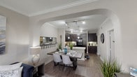 Located at 3306 S Fry Rd in Katy, TX, this single-floor residence offers a thoughtfully designed open-concept layout with modern finishes and a cohesive neutral color palette throughout. The living room is bright and welcoming, featuring crown molding, a ceiling fan, and large windows that invite natural light. An elegant arched passageway connects the living and dining areas, creating a smooth visual flow into the kitchen.

The kitchen is a standout feature, equipped with rich dark espresso cabinetry, light quartz countertops, a subway tile backsplash, and a full suite of black appliances including a range, microwave, dishwasher, and refrigerator. A peninsula with pendant lighting adds both function and style, complementing the track lighting overhead. Wood-look flooring extends throughout the main living areas, adding warmth and continuity.

The bedrooms are generously sized, each with plush carpet, ceiling fans, and ample natural light from well-placed windows. The bathroom features matching dark cabinetry, a broad vanity with a white countertop, a large mirror, and a full soaking tub with a shower combination. The overall design strikes a balance between contemporary style and practical comfort, making this a well-appointed and inviting Katy-area residence.