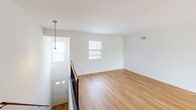 Located at Westridge Gardens in Phoenixville, PA, this two-story, one-bedroom, one-bathroom home offers a well-designed layout across two levels. The main level welcomes you through a front entry with pendant lighting and warm hardwood-style flooring that flows throughout. The open-concept kitchen and living area is bright and functional, highlighted by gray shaker cabinetry, dark granite countertops, a large kitchen island with pendant lights overhead, and stainless steel appliances including a refrigerator, electric range, and built-in microwave. Natural light fills the living area through a large window, creating an airy and inviting atmosphere. A private balcony off the main level offers peaceful views of open green space and surrounding trees. Upstairs, the generously sized bedroom features plush carpet, a bright window with natural views, and access to a dedicated walk-in closet complete with built-in shelving and hanging rods. The full bathroom includes a clean, all-white tub and shower surround with a built-in niche for added convenience. The overall aesthetic is clean and neutral, making this a move-in-ready home in a serene setting.