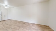 Located at 1701 N Jones Blvd in Las Vegas, NV, this 2-bedroom, 1-bathroom unit offers a well-designed single-floor layout with a clean, bright aesthetic throughout. Light wood-style flooring runs continuously across all rooms, creating a cohesive and airy feel.

The combined kitchen and living area serves as the heart of the home. The kitchen is equipped with white cabinetry offering ample storage, a gas range, refrigerator, dishwasher, double-basin sink, and light countertops. A ceiling fan and recessed lighting keep the space comfortable and well-lit. The adjacent living area features a front-facing window and a paneled entry door that brings in natural light.

Both bedrooms are generously sized with crisp white walls and large windows that frame views of the surrounding landscape, including mature trees and the neighborhood exterior. The primary bedroom features a sliding double-door closet, providing practical storage. The second bedroom also includes a closet and connects conveniently to the shared hallway.

The bathroom is well-appointed with a full tub-shower combination, a vanity with under-sink storage, a large mirror with overhead lighting, and matching wood-style flooring that ties the space together. The overall design is clean and functional, making it a practical and comfortable residence.