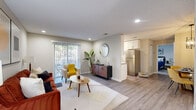 Located at 3343 Medlock Bridge Rd in Peachtree Corners, Georgia, this single-floor 2-bedroom, 1-bathroom residence offers a thoughtfully designed layout that makes efficient use of its space. The open-concept living room is finished with light wood-style flooring, recessed lighting, and neutral walls that create a bright, welcoming atmosphere. A sliding glass door fills the living area with natural light and provides access to an outdoor space with views of surrounding greenery. The kitchen features white shaker cabinetry, granite countertops, stainless steel appliances including a refrigerator, range, and microwave, and a window that adds additional natural light. The primary bedroom is a comfortable retreat with plush carpeting, a ceiling fan, and windows overlooking lush outdoor scenery. The second bedroom is equally well-lit, with large windows and soft carpeting. The bathroom is finished with large-format tile surrounding a soaking tub and shower. A dedicated closet area houses a stacked washer and dryer unit, providing in-unit laundry convenience. The overall design is clean and functional, with consistent neutral tones and modern finishes throughout.