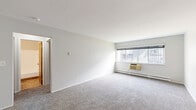 Located at 510 College Ave NE in Grand Rapids, Michigan, this one-bedroom, one-bathroom unit offers a practical and well-organized single-floor layout. The living area is spacious and open, featuring soft wall-to-wall carpeting, crisp white walls, and a large window that invites natural light while providing views of the surrounding neighborhood. A wall-mounted air conditioning unit and baseboard heating ensure year-round comfort.

The kitchen has been thoughtfully updated with contemporary flat-front cabinetry in a warm taupe finish, light-toned laminate flooring, and a marble-style tile backsplash. Stainless steel appliances — including a refrigerator, range, microwave, and dishwasher — round out the modern, functional cooking space.

The bedroom is a well-proportioned, carpeted room with a window allowing natural light and a built-in closet with bifold wooden doors, offering ample storage. Neutral-toned walls and a ceiling-mounted light fixture keep the room clean and versatile.

The bathroom features tile flooring in an earthy tone, a full-size soaking tub with a shower, a white vanity, and textured walls — a clean, no-frills space with all essential amenities. Overall, this unit presents a clean, move-in-ready layout suited for comfortable everyday living.