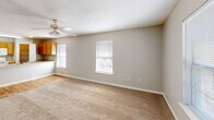 Located at 300 N Military Rd in Slidell, Louisiana, this single-story, one-bedroom, one-bathroom residence offers a practical and comfortable layout across a compact but well-utilized floor plan. The combined kitchen and living area forms the heart of the home, with the living room featuring neutral carpet, two windows that invite natural light, and a ceiling fan with integrated lighting. The kitchen is appointed with warm oak cabinetry, light countertops, white appliances including a range, refrigerator, and dishwasher, and a peninsula with a stainless steel sink. A dedicated pantry closet provides additional storage. Wood-look flooring runs throughout the kitchen and connecting areas, adding warmth and easy maintenance. The generously sized bedroom includes its own ceiling fan, a window with blinds, and direct access to a walk-in closet outfitted with wire shelving and hanging rods. The full bathroom features a single-vanity with oak cabinetry, a tub-shower combination, and a stacked washer and dryer unit, keeping laundry conveniently in-unit. Textured ceilings and neutral gray-toned walls are consistent throughout, creating a cohesive and understated aesthetic across the entire residence.
