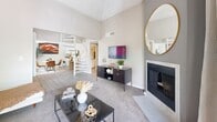 Located in Tucson, AZ, this two-bedroom, two-bathroom two-story residence offers a well-designed layout across two floors. The main level features a bright, open living room with soaring vaulted ceilings, plush carpet flooring, and a tiled fireplace that serves as a focal point. A striking spiral staircase connects the floors, adding an architectural charm to the space. The dining area flows seamlessly from the living room into the kitchen, which is outfitted in a galley-style layout with white cabinetry, dark countertops, stainless steel appliances, and light wood-look flooring. A private patio, laundry area, and a full bathroom with a tub-shower combination round out the main level. Upstairs, the generously sized primary bedroom stands out with a dramatic reclaimed wood accent wall, large windows offering outdoor views, and plush carpeting. A dedicated nook provides a quiet workspace. The second bedroom is equally comfortable, also featuring carpet and a closet. Both bathrooms are appointed with white vanity cabinetry and dark countertops. Throughout the home, a neutral color palette and consistent finishes create a cohesive, modern ambiance.