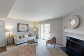 Located at 1126 Bonhomme Lake Dr in Olivette, Missouri, this single-floor, 2-bedroom, 2-bathroom residence offers a thoughtfully designed layout that balances comfort and functionality. The living room serves as the heart of the home, highlighted by a classic fireplace with a white mantel, soft carpeting, and a sliding glass door that opens to a private balcony overlooking lush, mature trees — filling the space with natural light and outdoor views. The adjacent dining area features track lighting overhead and connects seamlessly to the rest of the living space, creating an easy flow for daily living and entertaining. The kitchen is equipped with warm wood cabinetry, black appliances, and a generous granite-style breakfast bar with seating, complemented by a pass-through window that maintains an open connection to the living areas. The primary bedroom offers comfortable proportions with plush carpet, a mirrored sliding closet, and ample storage. The second bedroom is bright and inviting, with a large window that brings in natural light. Both bathrooms are well-appointed; one features a dual-sink vanity with wood cabinetry and hardwood flooring, alongside a tub-shower combination. Together, the rooms create a cohesive, comfortable living environment in a serene Olivette setting.