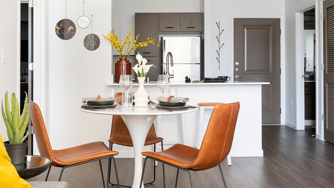 Cocina del apartamento con electrodomésticos de acero inoxidable y comedor con piso estilo madera. - Griffis Lake Washington