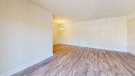 Located in the Village of Pine Court community in Windsor Mill, Maryland, this one-bedroom, one-bathroom residence offers a well-organized and efficiently designed single-floor layout. Throughout the space, durable hardwood-style plank flooring provides a cohesive and clean aesthetic that ties each room together seamlessly.

The living area is open and airy, featuring neutral cream-toned walls and a front entry door that welcomes abundant natural light. A separate dining area is distinguished by an elegant chandelier, adding a refined touch to the space.

The galley-style kitchen is thoughtfully designed with warm wood cabinetry lining both sides, providing generous storage space. White appliances — including a refrigerator, electric range, and dishwasher — complement the light countertops, while a window at the far end of the kitchen brings in natural light and outdoor views.

The spacious bedroom features a wide window with blinds that allow for controlled natural light, neutral walls, and the same consistent hardwood-style flooring. A dedicated closet offers practical storage, while an adjacent door leads conveniently to the rest of the unit.

The bathroom includes a light wood vanity, a wide white countertop with an extended surface, a full-width mirror, and a tiled shower, offering a clean and functional design. This well-maintained residence provides a comfortable and practical living environment.