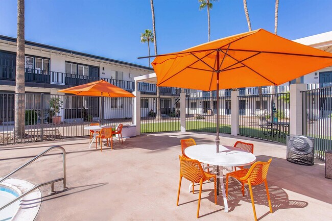Patio con sombrillas y sillas naranjas. - Miramonte on 3rd