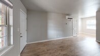 Located at 4455 E 31st St in Tulsa, Oklahoma, this single-floor, one-bedroom, two-bathroom unit offers a practical and well-appointed layout. The combined kitchen and living area is finished with durable wood-look flooring and neutral gray walls that create a clean, modern aesthetic. The living room receives natural light through a multi-pane window and features a wall-mounted climate control unit. The galley-style kitchen is efficiently organized with rich, dark espresso cabinetry, white countertops, stainless steel appliances including a refrigerator and range, recessed lighting, and a single-basin sink — providing solid functionality in a compact footprint. The bedroom is a comfortable, well-sized retreat finished with plush carpet, a ceiling fan with light fixture, a window with blinds for natural light and privacy, and access to a dedicated walk-in closet. The two bathrooms are finished with matching dark cabinetry and light-colored LVP flooring. One bathroom features a single-vanity with a large mirror and bright overhead lighting, while the other includes a full tub/shower combo with white tile surround and overhead storage cabinetry. A dedicated closet rounds out the layout, adding practical storage throughout the unit.