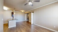 Located at 4 Stadium Dr in Angleton, TX, this one-bedroom, one-bathroom residence is thoughtfully designed to maximize every square foot of its single-floor layout. The open-concept living area features warm hardwood-style flooring, crown molding, and a ceiling fan with light kit, creating a comfortable and cohesive atmosphere. The kitchen is a standout feature, showcasing rich dark-wood cabinetry, granite countertops, a tile backsplash, and a full suite of stainless steel appliances including a refrigerator, range, and microwave. A peninsula with an overhang provides additional counter space and casual seating. The bedroom is carpeted and bright, with two windows offering natural light and views of the surrounding neighborhood, complemented by a ceiling fan and crown molding. The bathroom includes white cabinetry, a granite-topped vanity, tile flooring, and a separate shower area. Four closets—including a spacious walk-in with wire shelving—offer generous storage throughout. A dedicated laundry room accommodates a full-size washer and dryer. The unit also includes an outdoor patio with a white railing, offering a pleasant spot to enjoy the outdoors.