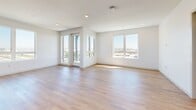 Located at 12888 Crenshaw Blvd in Gardena, CA, this thoughtfully designed one-bedroom, three-bathroom residence offers a clean, contemporary aesthetic across a single floor. Warm-toned hardwood-style flooring flows throughout, complementing the bright white walls and recessed lighting that give the space an open, airy feel.

The kitchen is a standout feature, outfitted with slate-blue shaker cabinetry, matte black hardware, a white quartz countertop, a mosaic tile backsplash, and a full suite of stainless steel appliances. A large window floods the kitchen and adjacent living area with natural light and offers views of the surrounding Gardena streetscape, while the open layout encourages easy flow between cooking and living spaces.

The bedroom is comfortably sized and bathed in natural light through a wide sliding window with outdoor views. Multiple closets, including a spacious walk-in with built-in hanging rods, provide ample storage throughout the unit. A hallway connects the main living areas to the private quarters with ease.

The three bathrooms are finished in a modern style, with one featuring a soaking tub surrounded by large-format gray stone-look tile, matte black fixtures, a curved shower rod, and a sleek gray vanity with an LED-lit mirror. A private balcony, in-unit laundry, and a well-organized layout round out this polished and functional residence.