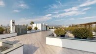 Located in the heart of Los Angeles at 5639 Lexington Ave, this rooftop terrace offers a striking open-air retreat designed with both aesthetics and functionality in mind. The deck is finished with light wood-look porcelain tile laid in a herringbone-style pattern, lending a warm, contemporary feel underfoot across the generous expanse of the space.

Strategically arranged raised planter beds with crisp white stucco exteriors and slate-toned coping define the layout, filled with neatly manicured shrubs, ornamental trees, and decorative gravel. These planters provide natural separation between zones while adding lush greenery throughout. Dark charcoal planter pots complement the modern palette of the terrace.

The space features multiple seating and gathering areas, including long communal tables with benches, ideal for social or event use. A metal pergola structure on one end offers a shaded retreat, while a freestanding architectural chimney element serves as a focal point. Iron railing fencing lines the perimeter, ensuring safety without interrupting the breathtaking panoramic views.

From nearly every vantage point, the terrace reveals sweeping sightlines encompassing the Los Angeles cityscape, the Hollywood Hills, and tall palm trees characteristic of Southern California. Abundant natural light fills the space throughout the day, making it a truly memorable outdoor destination.