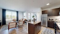 Located at 250 Summit Blvd in Broomfield, Colorado, this thoughtfully designed one-bedroom, one-bathroom residence offers a functional and stylish single-floor layout. The open-concept living and kitchen area serves as the heart of the home, featuring rich dark-wood cabinetry, stainless steel appliances, a classic white subway tile backsplash, and a central island with bar seating — ideal for casual dining or entertaining. Light hardwood flooring flows throughout the main living areas, complementing the bright, neutral color palette. The living room is generously sized, bathed in natural light from large windows dressed with contemporary dark curtains, creating a warm and inviting atmosphere. The bedroom offers a comfortable retreat with plush carpet, a ceiling fan, and large windows that bring in ample natural light. A dedicated closet provides convenient storage. The bathroom is clean and well-finished, featuring a tiled tub-shower combination, wood-toned vanity, and light hardwood flooring. Crisp white walls and modern brushed nickel fixtures tie the space together with a cohesive, contemporary aesthetic throughout.