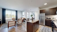 Located at 250 Summit Blvd in Broomfield, Colorado, this thoughtfully designed one-bedroom, one-bathroom residence offers a functional and stylish single-floor layout. The open-concept living and kitchen area serves as the heart of the home, featuring rich dark-wood cabinetry, stainless steel appliances, a classic white subway tile backsplash, and a central island with bar seating — ideal for casual dining or entertaining. Light hardwood flooring flows throughout the main living areas, complementing the bright, neutral color palette. The living room is generously sized, bathed in natural light from large windows dressed with contemporary dark curtains, creating a warm and inviting atmosphere. The bedroom offers a comfortable retreat with plush carpet, a ceiling fan, and large windows that bring in ample natural light. A dedicated closet provides convenient storage. The bathroom is clean and well-finished, featuring a tiled tub-shower combination, wood-toned vanity, and light hardwood flooring. Crisp white walls and modern brushed nickel fixtures tie the space together with a cohesive, contemporary aesthetic throughout.
