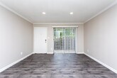Located at 1871 Plaza Ln SW in Atlanta, GA, this single-floor unit offers a well-designed layout with updated finishes throughout. The open living area features durable hardwood-style flooring, recessed lighting, and crown molding, creating a clean and inviting atmosphere. A sliding glass door floods the space with natural light and provides direct access to the outdoors.

The galley-style kitchen is thoughtfully appointed with white shaker cabinetry, gray laminate countertops, a mosaic tile backsplash, and black appliances including a gas range, dishwasher, and refrigerator. A stainless steel sink and an exterior-facing window add both function and brightness to the space.

The bedrooms are comfortably sized and feature plush wall-to-wall carpeting for a warm, cozy feel. One bedroom includes a closet with bi-fold doors, while another offers additional storage. Neutral wall tones throughout lend a versatile backdrop suitable for a variety of interior styles.

The bathroom is finished with white tile walls, wood-look vinyl flooring, and a walk-in shower, complemented by a window that allows natural light to brighten the room. Overall, this unit presents a practical and updated living environment in a convenient Atlanta location.