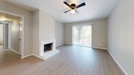 Located in Houston's desirable 77056 corridor, this well-appointed 3-bedroom, 3-bathroom residence offers a thoughtfully designed single-floor layout with a generous, flowing floor plan. Light wood-style flooring runs throughout, creating a bright and cohesive aesthetic. The open living room is anchored by a white brick wood-burning fireplace and a ceiling fan, with sliding glass doors that lead directly to a private balcony overlooking lush, tree-lined surroundings with a skylight overhead. The kitchen features white cabinetry, granite-look countertops, stainless steel appliances, and a pass-through opening to the living area, allowing natural light to flow freely. Each bedroom is well-proportioned, with the primary suite offering its own sliding glass door access to the balcony, a ceiling fan, and a spacious walk-in closet outfitted with built-in shelving and hanging rods. The primary bathroom includes an extended vanity with granite-look counters, white cabinetry, and a large mirror with overhead lighting. Additional bathrooms provide clean, tiled tub-shower combinations. The entrance and hallway connect all spaces efficiently, completing a comfortable and functional residence.