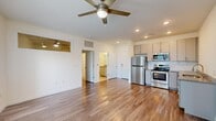 Located at 947 Myers St in Richmond, VA, this efficiently designed one-bedroom, one-bathroom residence offers a thoughtful layout across a single floor. The open-concept kitchen and living area serves as the heart of the unit, featuring warm hardwood-style flooring, recessed lighting, and a ceiling fan that enhances air circulation and comfort. The kitchen is well-appointed with stainless steel appliances — including a refrigerator, range, microwave, and dishwasher — complemented by granite-style countertops, a subway tile backsplash, and gray cabinetry offering ample storage. Natural light flows into the living area through a large window, while an interior transom window connects the bedroom visually to the main living space. The bedroom is a comfortable, quiet retreat with its own ceiling fan, a large exterior window with blinds, direct access to the full bathroom, and an adjacent dedicated laundry room housing a stacked washer and dryer unit. The bathroom features tile flooring, a granite-topped vanity, and a bathtub. Clean white walls and consistent hardwood-style flooring throughout give the space a cohesive, modern aesthetic well-suited for everyday living.