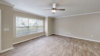 Located at 100 Alexander Xing in Loganville, Georgia, this two-story home offers a well-organized layout spread across two floors. The main level features an open-concept living, dining, and kitchen area finished with wood-look luxury vinyl plank flooring and neutral warm-toned walls throughout. Crown molding and ceiling fans with light fixtures add a polished touch to the living and dining spaces, which benefit from natural light through large windows with blinds and access to an exterior door. The kitchen is outfitted with crisp white cabinetry, a tiled backsplash, white quartz countertops, a stainless steel sink, and stainless steel appliances including a range, microwave, and refrigerator. A peninsula counter connects the kitchen to the open living area. A dedicated laundry space on the main level accommodates a full-size washer and dryer. Upstairs, the three bedrooms feature plush carpeting, ceiling fans, and windows that bring in natural light. The generously sized primary bedroom offers ample space. Three closets are distributed throughout the home. The two bathrooms include clean white fixtures, a tub-shower combo, white vanity cabinetry, and wood-look flooring, maintaining a consistent, cohesive aesthetic throughout the home.