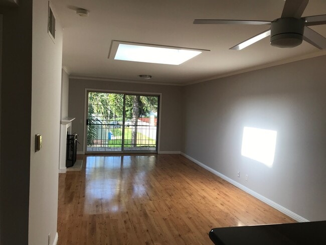 The spacious great room features a ceiling fan, skylight, cozy fireplace, abundant natural light - 6484 Cavalleri Rd