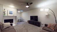 Located at 4500 Cherry Hill Ln in Oklahoma City, Oklahoma, this single-floor home offers a practical and comfortable layout designed for everyday living. The open-concept living and dining area serves as the heart of the home, featuring neutral-toned walls, plush carpeting, and a ceiling fan that adds both function and style. A brick-surround fireplace anchors the living space, while a skylight overhead brings in natural light, brightening the combined living and dining area. The dining space accommodates a full table and chairs, making it ideal for meals and gatherings. The living area also includes ample seating space and a large window that allows additional natural light to fill the room. The kitchen is equipped with stainless steel appliances, including an electric range and refrigerator, complemented by white cabinetry and wood-look flooring that adds warmth and durability. Two carpeted bedrooms each feature windows with decorative curtains, providing natural light and a cozy atmosphere. The full bathroom is well-appointed with a tiled shower-tub combination, a vanity with a stone-look countertop, and wood-look flooring. Throughout the home, a consistent neutral color palette creates a cohesive and inviting ambiance.