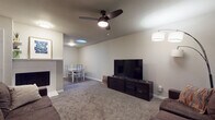 Located at 4500 Cherry Hill Ln in Oklahoma City, Oklahoma, this single-floor home offers a practical and comfortable layout designed for everyday living. The open-concept living and dining area serves as the heart of the home, featuring neutral-toned walls, plush carpeting, and a ceiling fan that adds both function and style. A brick-surround fireplace anchors the living space, while a skylight overhead brings in natural light, brightening the combined living and dining area. The dining space accommodates a full table and chairs, making it ideal for meals and gatherings. The living area also includes ample seating space and a large window that allows additional natural light to fill the room. The kitchen is equipped with stainless steel appliances, including an electric range and refrigerator, complemented by white cabinetry and wood-look flooring that adds warmth and durability. Two carpeted bedrooms each feature windows with decorative curtains, providing natural light and a cozy atmosphere. The full bathroom is well-appointed with a tiled shower-tub combination, a vanity with a stone-look countertop, and wood-look flooring. Throughout the home, a consistent neutral color palette creates a cohesive and inviting ambiance.