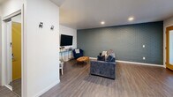Located at 516 NW 8th St in Oklahoma City, this one-bedroom, two-bathroom unit offers a efficiently designed single-floor layout with modern updates throughout. Wood-look flooring flows consistently across the living, dining, kitchen, and bedroom areas, creating a cohesive aesthetic.

The living room is a standout space, anchored by a painted brick accent wall in a muted green tone and recessed lighting overhead. The combined dining and kitchen area features crisp white shaker cabinetry extending to the ceiling, white quartz countertops, black appliances including a refrigerator and electric range, and a textured geometric accent wall that adds visual interest to the dining nook.

The spacious primary bedroom benefits from natural light through a large window and includes a distinctive sliding barn door that opens to a dedicated en-suite bathroom and closet. The en-suite bathroom showcases floor-to-ceiling marble-look tile in a walk-in glass shower with sleek chrome fixtures. A second bathroom offers a clean white vanity with an undermount sink and wood-framed mirror. Additional highlights include two closets for ample storage and a private patio. Recessed lighting throughout the unit ensures a bright, well-lit environment.