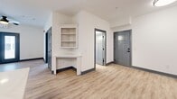 Located at 100 Hunter Hill Rd in Tarboro, NC, this single-story 2-bedroom, 2-bathroom home offers a clean, modern aesthetic with consistent light wood-look flooring and crisp white walls throughout. Charcoal-gray door and window trim provide a striking contrast that ties the design together cohesively.

The kitchen is a standout feature, showcasing white shaker-style cabinetry, white quartz countertops, stainless steel appliances including a range and refrigerator, and a center island with a built-in sink and pendant lighting. A dedicated laundry area is conveniently accessible directly from the kitchen.

The open living and dining area flows naturally from the kitchen, offering a spacious, versatile layout. A built-in corner shelving unit adds a charming, functional touch to the living space. Both bedrooms are comfortably sized and feature ceiling fans and windows that invite natural light. The primary bedroom includes direct access to its own bathroom.

Each bathroom is finished with white cabinetry, quartz countertops, undermount sinks, and stylish arched mirrors with modern fixtures. The home also includes three closets — one a walk-in with built-in shelving and hanging rods — providing ample storage. A patio rounds out the home, offering outdoor space for relaxation.