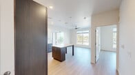 Located at 9990 E Harvard Ave in Denver, Colorado, this modern 2-bedroom, 2-bathroom residence offers a thoughtfully designed open-concept layout with clean contemporary finishes throughout. Light wood-tone flooring flows seamlessly across the entire space, lending warmth and visual continuity to every room.

The kitchen is a standout feature, equipped with a full suite of stainless steel appliances—including a French door refrigerator, range, microwave, and dishwasher—complemented by a two-tone cabinet design pairing dark espresso lower cabinets with crisp white uppers, a subway tile backsplash, and a central island with a white countertop. The adjoining living area is bright and airy, highlighted by large sliding glass doors that open to a private balcony offering treetop views of the surrounding Denver landscape and a ceiling fan overhead.

Both bedrooms are well-proportioned, each featuring large windows that invite abundant natural light and elevated outdoor views. The two bathrooms are finished in a clean, modern style, with dark vanity cabinetry, white quartz countertops, round mirrors, and tiled tub-shower combinations with chrome fixtures. A dedicated closet provides practical storage. The overall ambiance is bright, minimalist, and move-in ready.