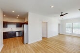 Located at 1400 SW Railroad Ave in Hammond, Louisiana, this two-bedroom, one-bathroom unit offers a well-organized single-floor layout with a clean, modern aesthetic throughout. Light wood-tone flooring runs continuously across all rooms, creating a cohesive and bright feel.

The open-concept kitchen and living area forms the heart of the home. The kitchen is outfitted with rich dark-stained wood cabinetry, white countertops, a stainless steel refrigerator, electric range, and built-in microwave. A stainless sink is positioned under a window, allowing for natural light while cooking. The adjacent living area is spacious and open, featuring recessed lighting and a ceiling fan, with multiple windows fitted with blinds that allow for ample natural light.

Both bedrooms are generously sized, each equipped with ceiling fans and windows that bring in natural light. The primary bedroom is notably spacious and includes a dedicated closet with wire shelving systems offering practical storage. An additional walk-in closet with multi-tier wire shelving provides further storage capacity.

The bathroom features a full tub-shower combination, a vanity with dark wood cabinetry and a white countertop, and clean white finishes throughout. The unit's neutral color palette and consistent flooring give it a fresh, move-in-ready appearance.