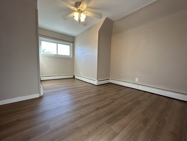 Dormitorio 1 con ventilador de techo y suelo de vinilo completamente nuevo. - 1231 Raymond Ave