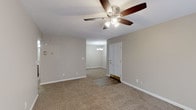 Located at 3106 E 51st St in Tulsa, Oklahoma, this single-story home offers a well-organized layout with a neutral color palette and a blend of practical finishes throughout. The main living area features plush carpeting, warm beige walls, and a ceiling fan with integrated lighting, creating a comfortable and functional space. An adjacent area, accented by a chandelier, provides a defined dining or secondary gathering space, with a panel door serving as the entry point between zones.

The bedrooms continue the carpeted flooring and neutral tones, each equipped with ceiling fans. One bedroom benefits from a sliding glass door fitted with vertical blinds, allowing natural light to filter in. The kitchen is outfitted with warm wood cabinetry, granite-style countertops, tile flooring, and stainless steel appliances including a refrigerator, gas range, microwave, and dishwasher, along with recessed lighting overhead.

The bathroom features wood-look vinyl plank flooring, a warm-toned vanity with granite countertops, and a separate wet area with a full tub and white tile surround. White trim and baseboards are consistent throughout, contributing to a clean, cohesive appearance across the entire home.