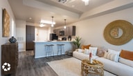 This single-story unit in Lubbock, Texas offers a thoughtfully designed open-concept layout that connects the living area and kitchen into one cohesive, functional space. The living room features a tray ceiling with a ceiling fan, warm neutral walls, and durable wood-style flooring that extends throughout the unit, creating a consistent, modern aesthetic.

The kitchen is generously sized and equipped with dark espresso-toned cabinetry, white countertops, and a full suite of black appliances including a refrigerator, range, microwave, and dishwasher. A peninsula with bar seating bridges the kitchen and living area, ideal for casual dining or entertaining. Pendant lighting adds a refined touch overhead.

The bedrooms are comfortably proportioned, with large windows that admit ample natural light. Ceiling fans provide additional climate control, and the wood-style flooring continues into each room. The bathrooms feature dark wood-finish vanities with white countertops, wood-style flooring, and upper cabinetry for added storage. One bathroom includes a shower-tub combination, while another offers a single-vanity configuration. The unit also includes in-unit laundry. Overall, the space presents a clean, contemporary design with warm, welcoming finishes.