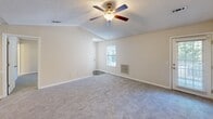Located in Mauldin, South Carolina, this 2-bedroom, 3-bathroom residence offers a thoughtfully arranged single-floor layout designed for comfortable everyday living. The open living room is a standout feature, boasting vaulted ceilings with a ceiling fan and light kit, soft carpeting, and a window that brings in natural light — creating an airy, welcoming atmosphere. The kitchen is equipped with an electric range, over-the-range microwave, and light wood cabinetry, and flows seamlessly into a dining area finished with wood-look luxury vinyl plank flooring and recessed lighting. Both bedrooms are carpeted and include ceiling fans, with the primary bedroom offering generous proportions and a spacious walk-in closet fitted with wire shelving for ample storage. The second bedroom also benefits from natural light via a window overlooking the exterior. All three bathrooms are finished with wood-look vinyl flooring and neutral wall tones; one features a full tub-shower combination with brushed nickel hardware and a single-sink vanity with built-in cabinetry. A dedicated laundry room with wire shelving and utility hookups adds everyday convenience. Throughout the residence, warm beige tones, white trim, and consistent flooring materials create a cohesive and clean aesthetic.