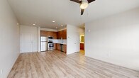 This 2-bedroom, 2-bathroom residence at 3214 Broadway Ave in Everett, WA offers a well-designed, single-floor layout with a clean, modern aesthetic throughout. Light wood-tone flooring flows seamlessly across the entire unit, complementing the neutral white walls and creating a bright, cohesive feel.

The open-concept living, dining, and kitchen area forms the heart of the unit. The kitchen is outfitted with warm wood-grain cabinetry, white quartz countertops, a full suite of stainless steel appliances including a refrigerator, range, microwave, and dishwasher, and recessed lighting above. A ceiling fan anchors the living area, which benefits from a large bank of windows offering expansive city views.

The primary bedroom is a comfortable, well-proportioned space featuring a ceiling fan, a generous walk-in closet, and a private ensuite bathroom. The ensuite includes a walk-in shower, wood-tone vanity cabinetry, and a large mirror. A second bedroom also includes a ceiling fan and closet. The second full bathroom features a soaking tub and shower combo with clean white surrounds and matching wood-tone vanity.

Additional highlights include in-unit stacked laundry, multiple closets for storage, and a hallway connecting all rooms efficiently. The unit presents a move-in-ready, contemporary living experience in downtown Everett.
