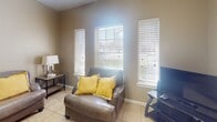 Located at 900 Travis St in Mission, Texas, this single-story home offers a well-organized and functional layout designed for comfortable living. The kitchen is outfitted with warm honey-toned oak cabinetry, granite-look countertops, and a decorative stone tile backsplash that adds texture and character. White appliances including an electric range and dishwasher provide everyday practicality, while ample upper and lower cabinet storage keeps the space efficient. The living area is bright and welcoming, featuring neutral taupe walls, light tile flooring, and multiple windows dressed with white faux-wood blinds that allow generous natural light to fill the room. The space comfortably accommodates a full seating arrangement, making it ideal for relaxing or entertaining. The bedrooms maintain the same warm, neutral palette with tile flooring, ceiling fans, and windows with blinds, offering a calm and restful environment with adequate storage including a tall chest of drawers. The bathroom is cleanly appointed with tile flooring, a shower-tub combination with a striped curtain, a vanity with wood cabinetry, and a wall-mounted storage cabinet. Throughout the home, the consistent use of light tile flooring and soft neutral tones creates a cohesive and inviting atmosphere suited to the warm South Texas climate.