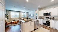This single-story, 2-bedroom, 2-bathroom residence features a thoughtfully designed open-concept layout that seamlessly connects the kitchen, dining, and living areas. The kitchen is outfitted with crisp white shaker cabinetry, granite countertops, a central island with an undermount sink, and a full suite of stainless steel appliances including a refrigerator, range, microwave, and dishwasher. The dining area sits adjacent, bathed in natural light from a large window with elegant draping. The living room is spacious and inviting, featuring wood-style flooring, recessed lighting, a ceiling fan, and large windows that frame outdoor views. The primary bedroom offers a comfortable retreat with a teal accent wall, a ceiling fan, wide windows, and a dedicated closet with built-in shelving. The second bedroom mirrors the same bright, airy quality with its own generous window and wood-style flooring. Each bathroom is finished with white vanity cabinetry, granite countertops, a tiled tub-shower combo, and wood-style flooring. Two closets, including a walk-in, provide ample storage. Neutral tones and consistent finishes throughout give the space a cohesive, modern aesthetic.